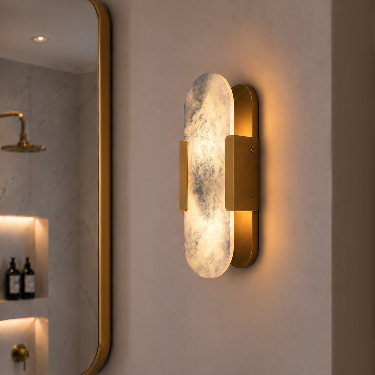 Glowing oval capsule Spanish natural alabaster wall light mounted beside a golden frame mirror in a bathroom