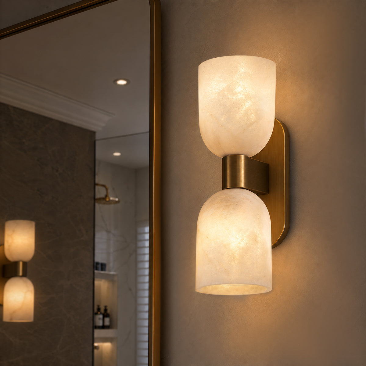Illuminated double capsule Spanish alabaster wall sconce installed on wall next to vanity mirror in bathroom