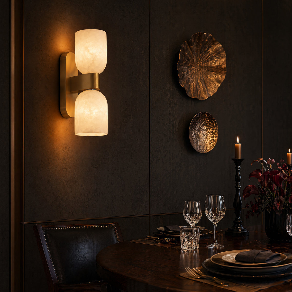 Warmly glowing Spanish natural alabaster double capsule wall light mounted on dark wall in moody dining room