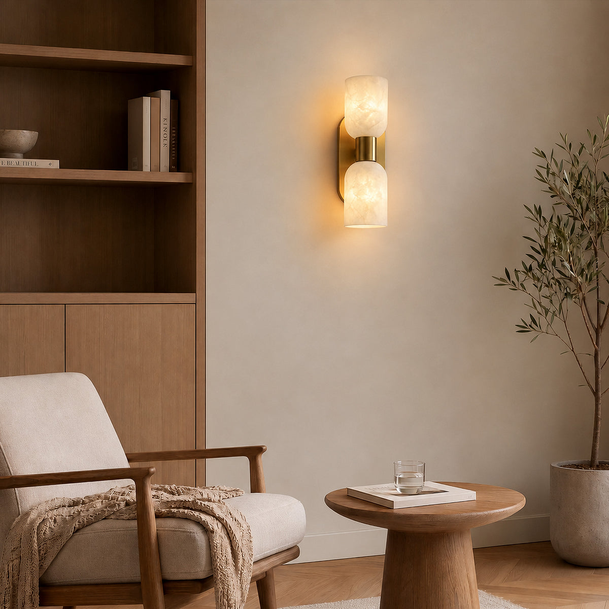 Glowing double capsule Spanish alabaster wall sconce mounted above wooden side table and armchair in minimalist lounge