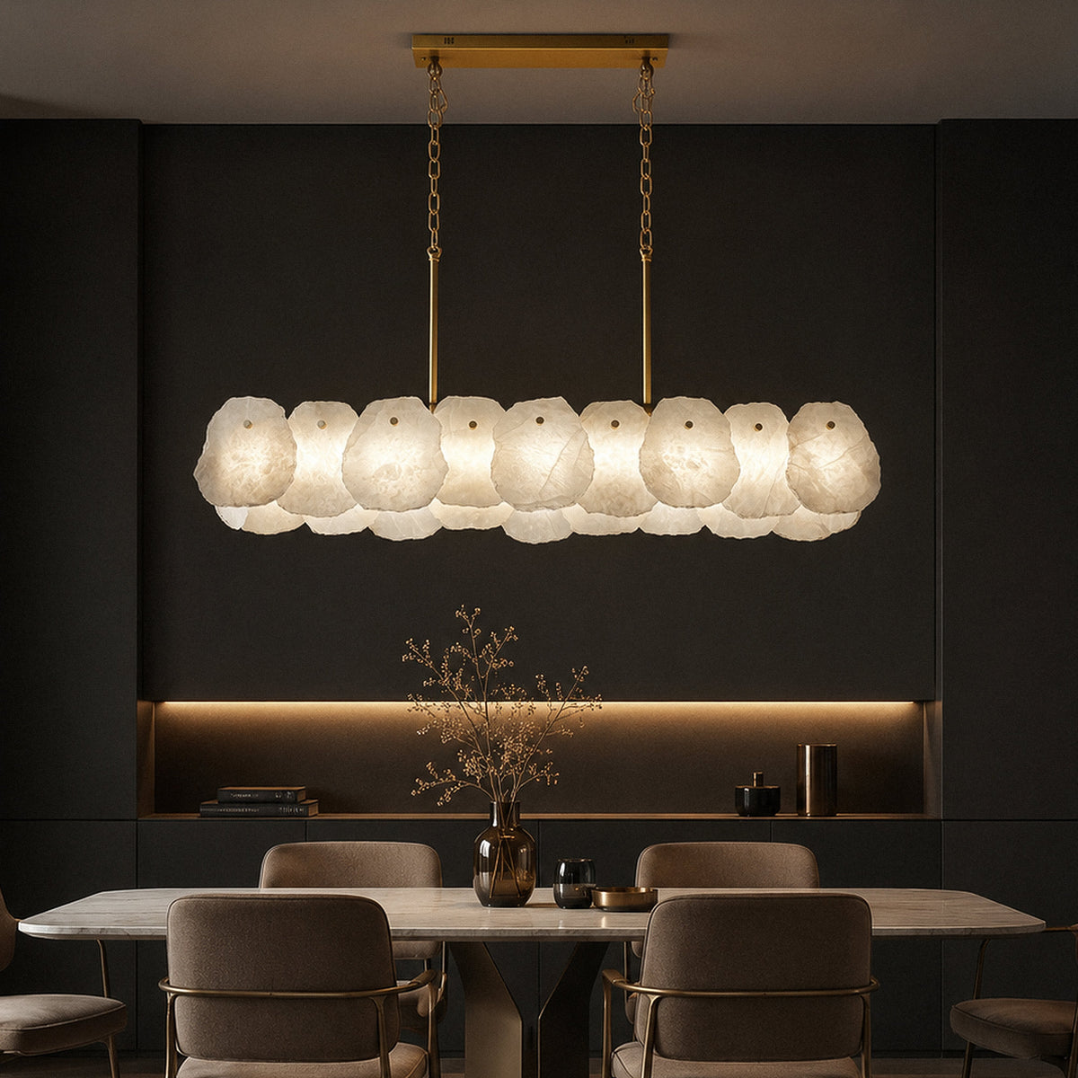 Spanish alabaster chandelier glowing over sleek dining table set against dark accent wall