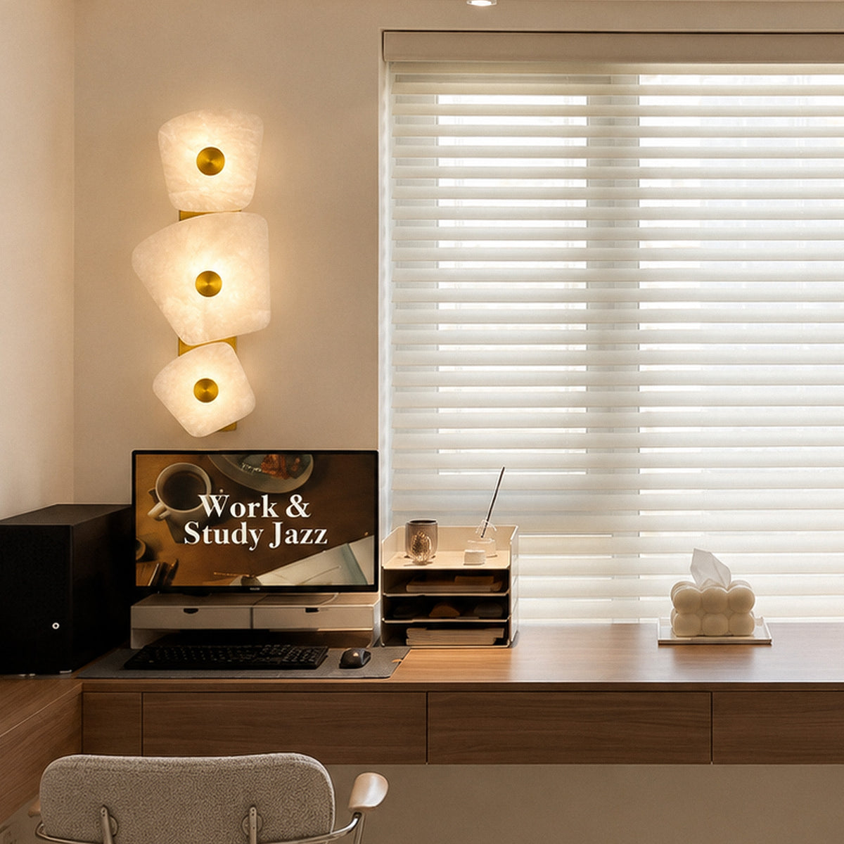 Organic Spanish alabaster wall sconce glowing beside desk with computer monitor and window blinds