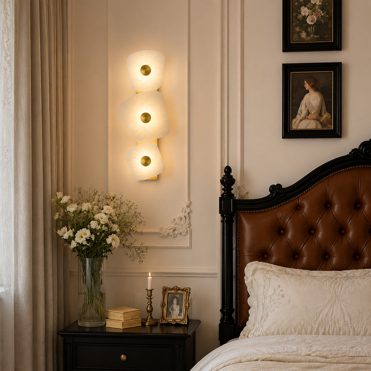 Organic Spanish alabaster wall sconce glowing beside classic leather tufted headboard in bedroom