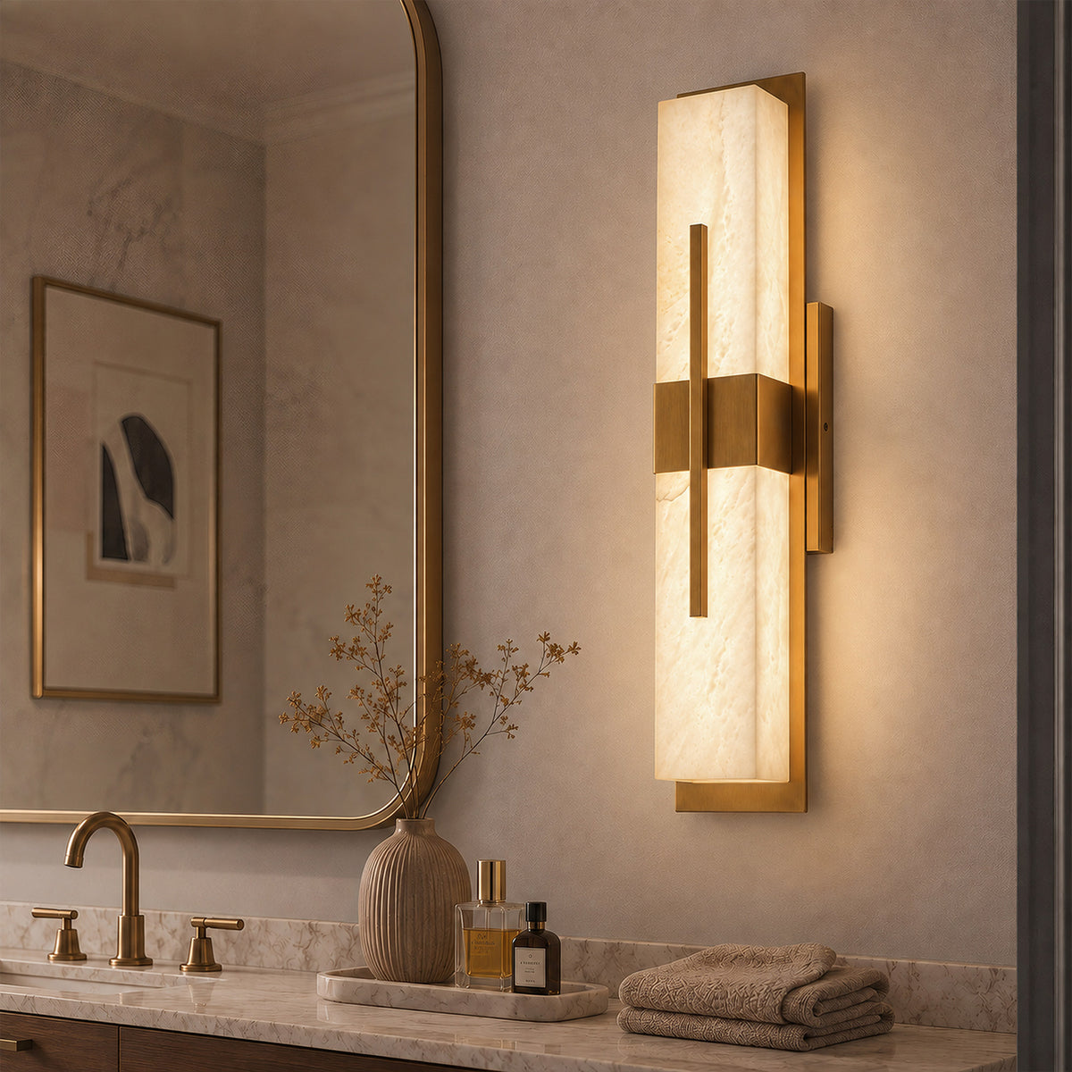 Glowing rectangular Spanish alabaster wall light mounted beside a brass frame bathroom mirror above a marble vanity unit
