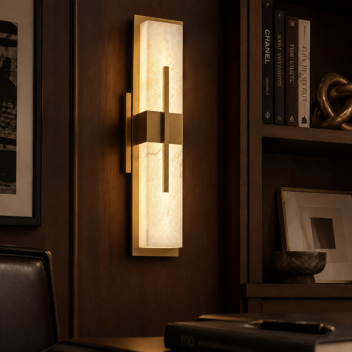 Illuminated Spanish alabaster rectangular wall sconce mounted on dark walnut wood paneling near bookshelf in mood lighting