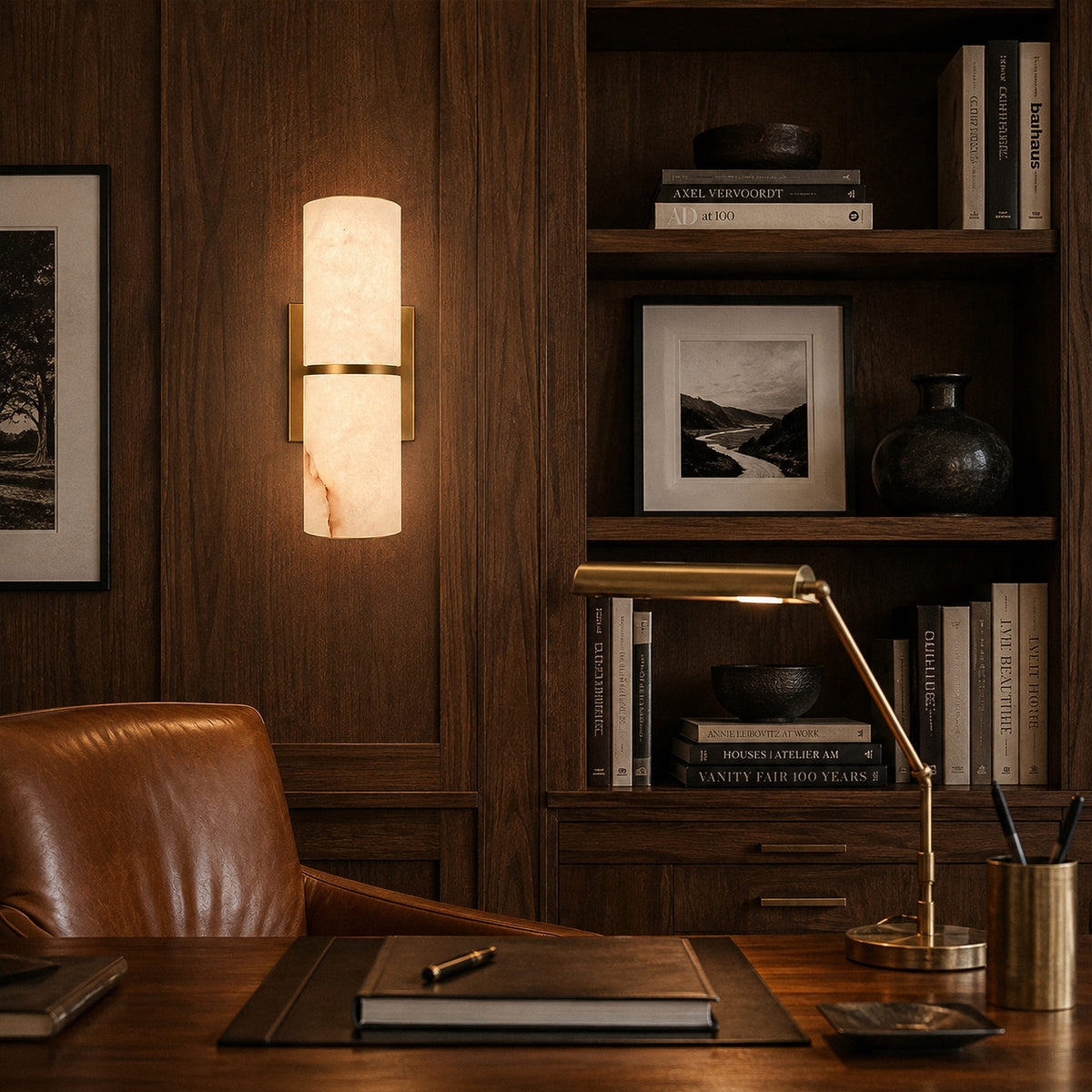 Spanish alabaster wall sconce glowing on dark wood wall paneling in upscale home office study room