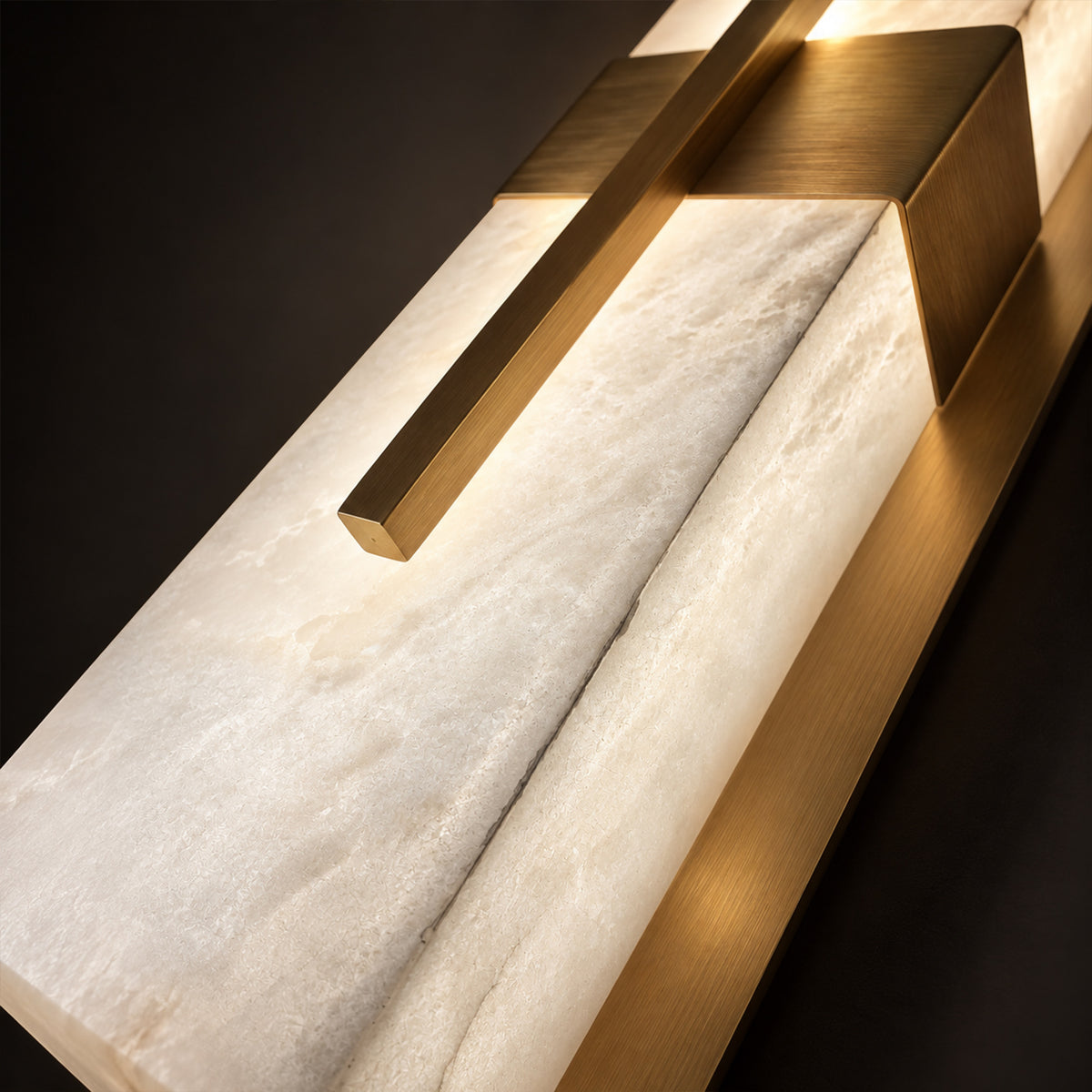 Detailed close up showing the light diffusion through natural Spanish alabaster stone and brushed brass metal cross fixture