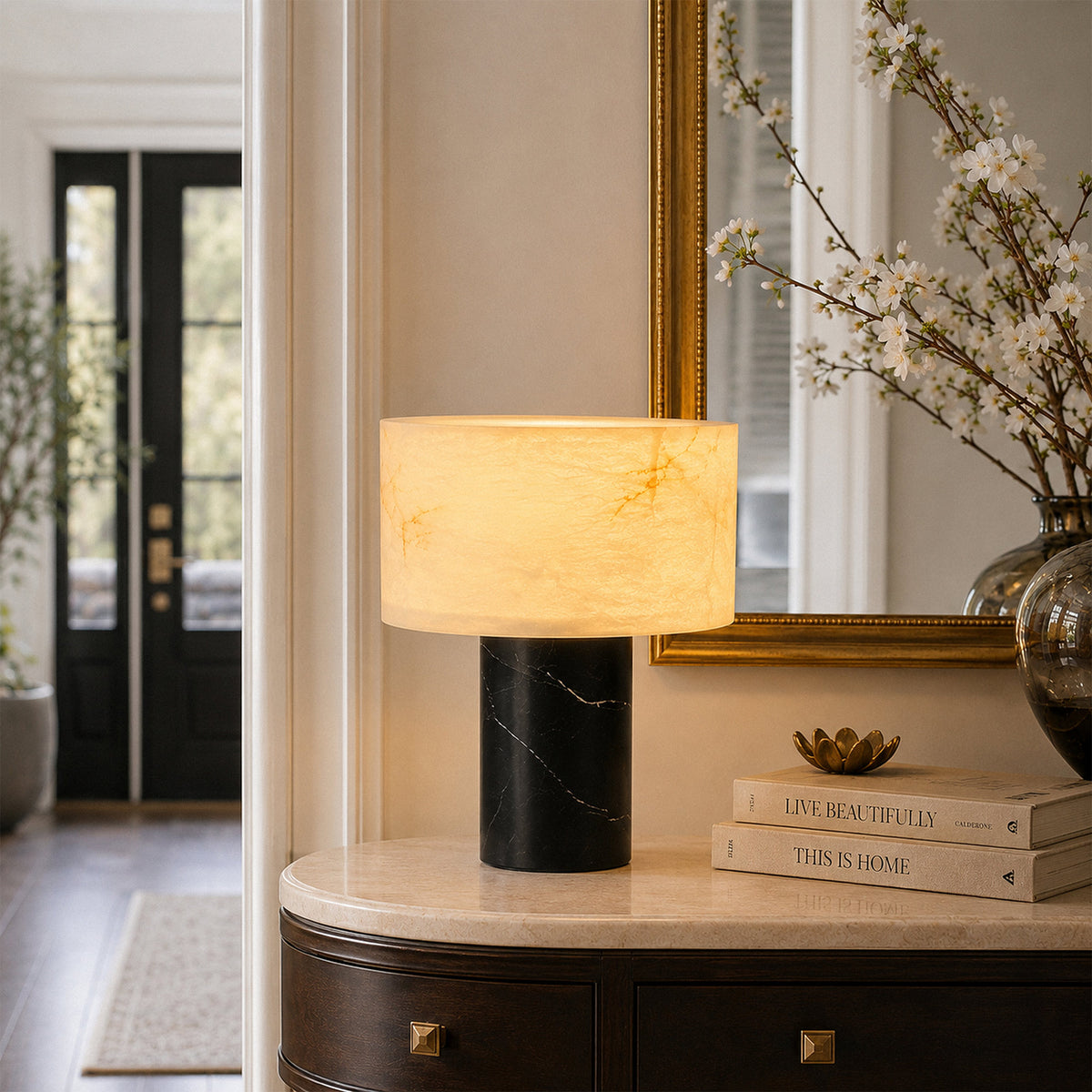 Alabaster table lamp providing warm ambient light on marble console table in elegant hallway entryway