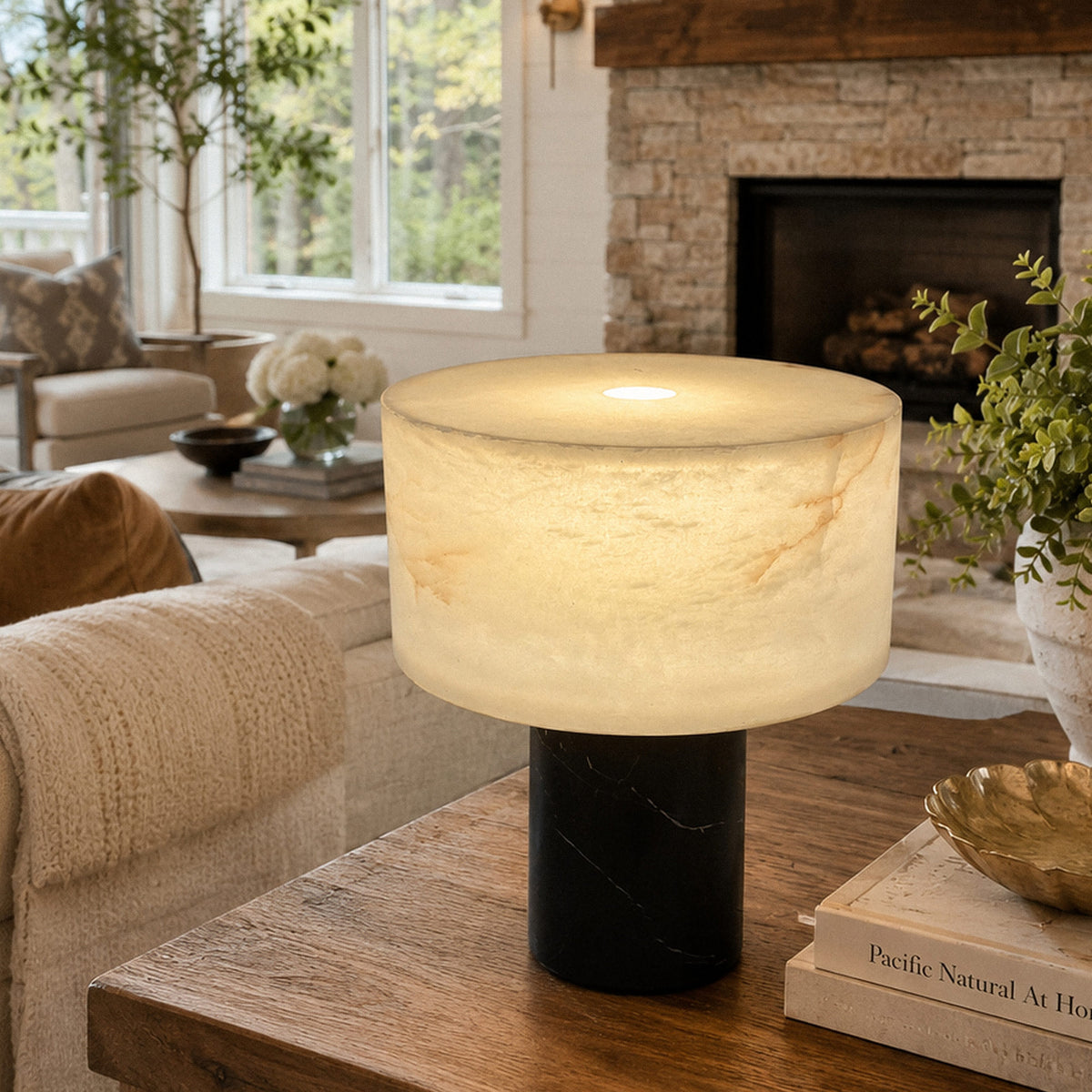 Glowing Spanish alabaster table lamp placed on wooden side table near sofa in modern living room