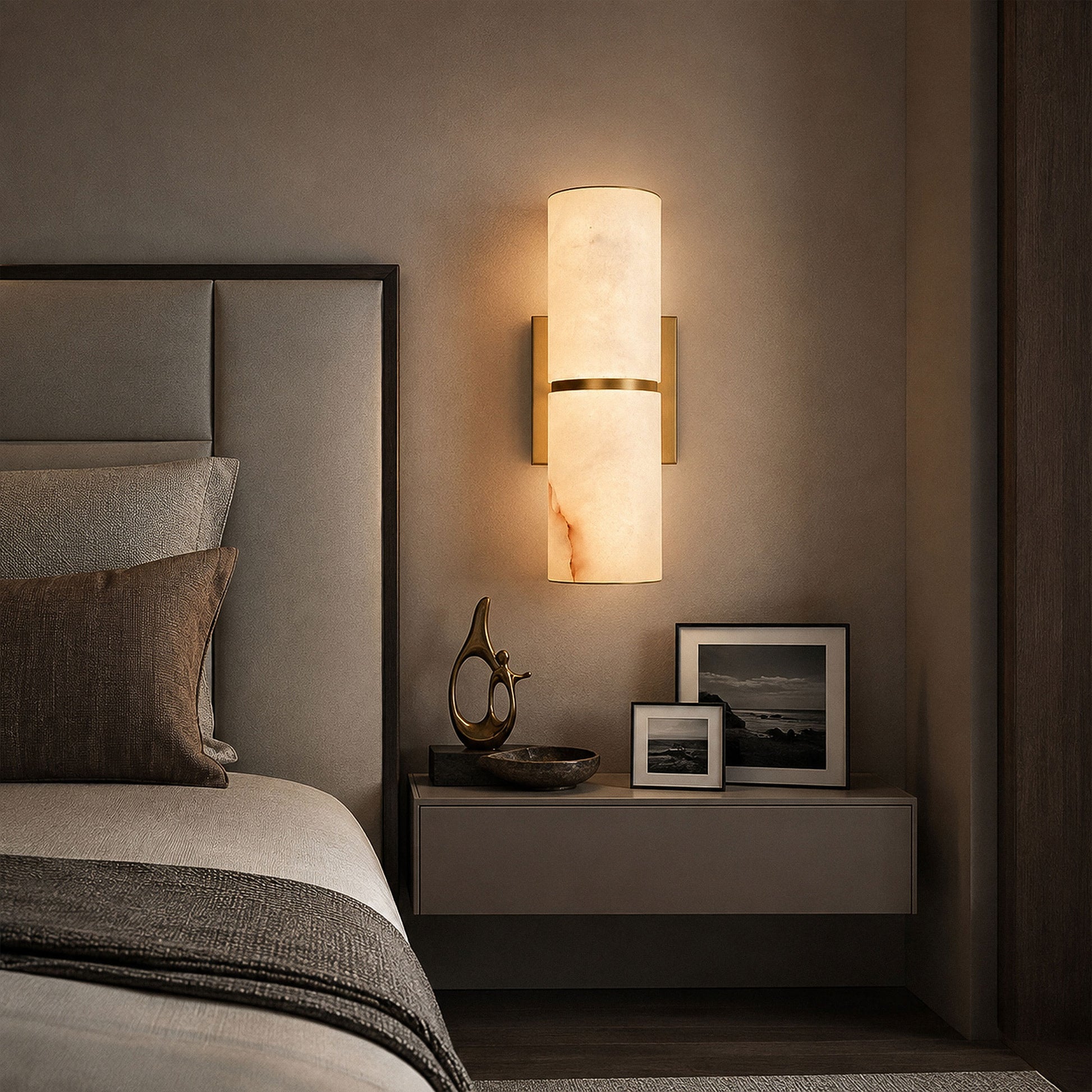 Spanish alabaster wall light illuminating dark moody bedroom setting beside upholstered headboard and nightstand