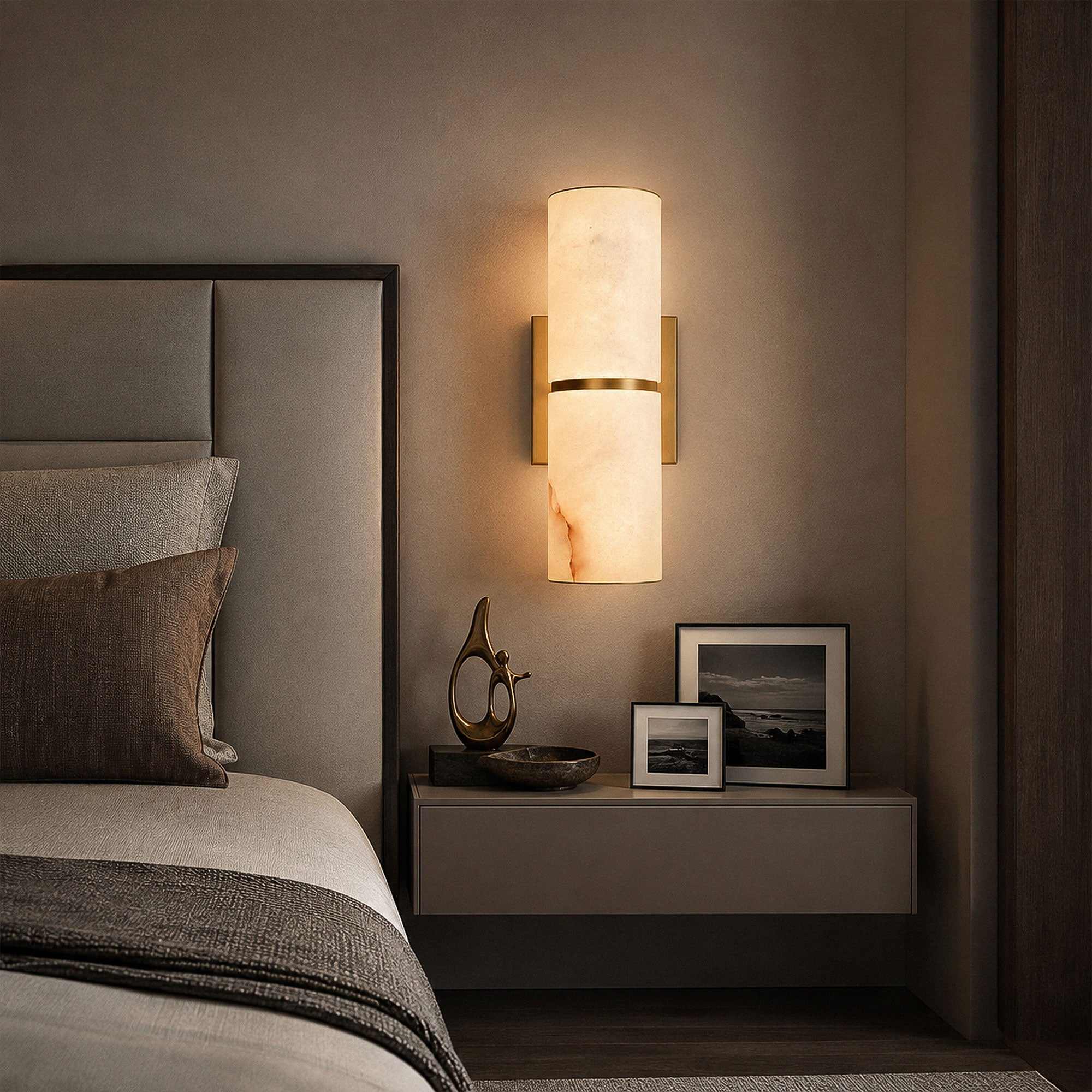 Spanish alabaster wall light illuminating dark moody bedroom setting beside upholstered headboard and nightstand