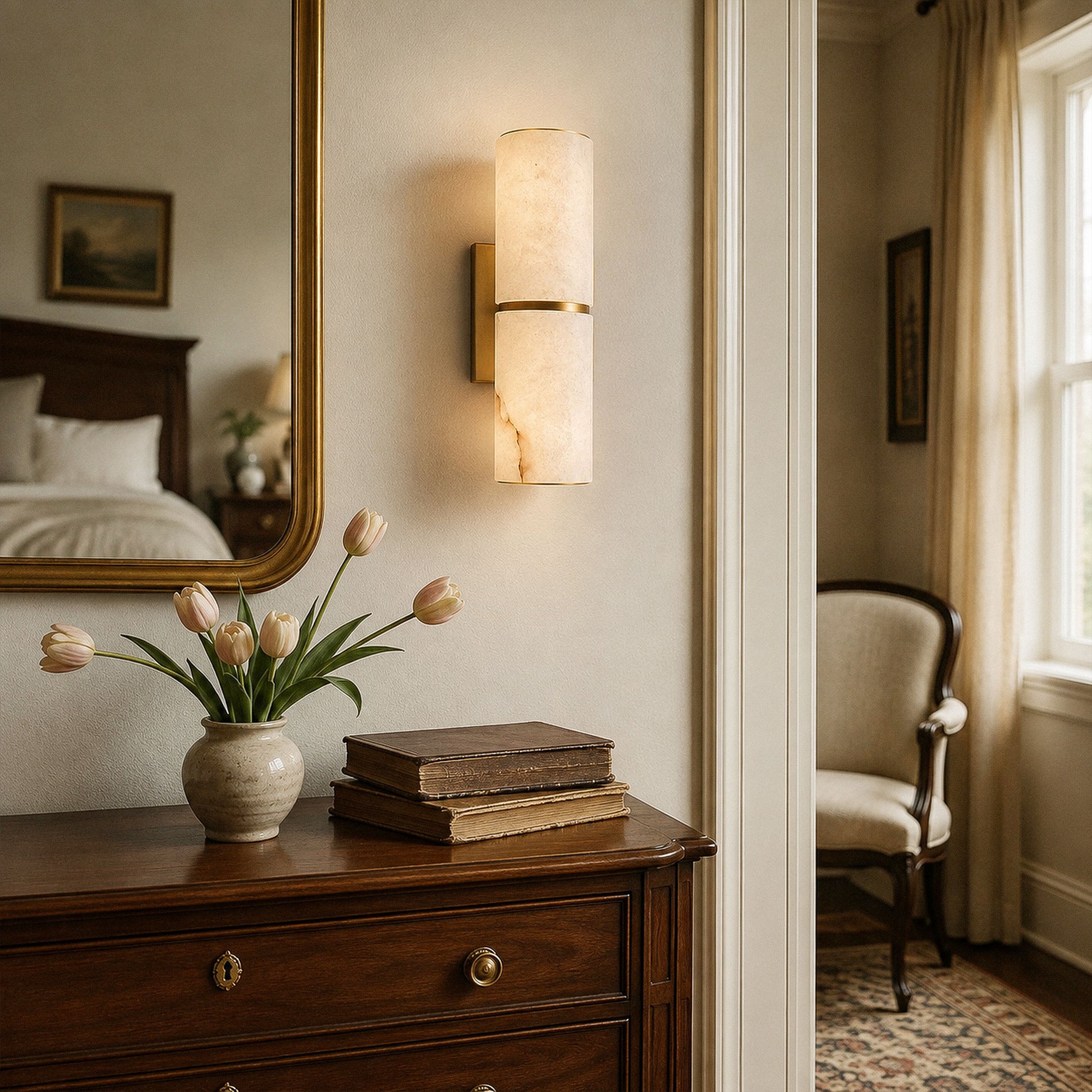 Spanish alabaster wall sconce illuminated on wall above dark wood console table with mirror in vintage hallway