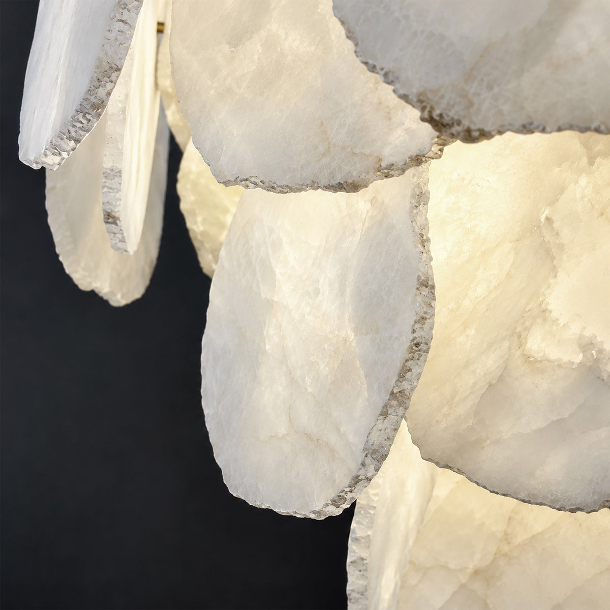 Macro close up of three tiered chiseled edge natural Spanish alabaster stone slices showing delicate translucent grain pattern
