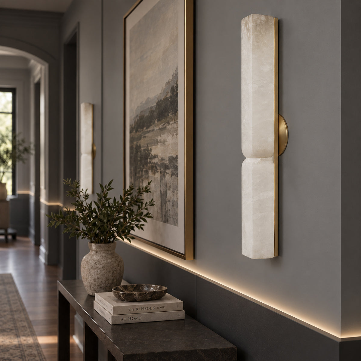 Unlit sculpted Spanish alabaster wall sconce mounted on grey wall in a modern residential hallway corridor