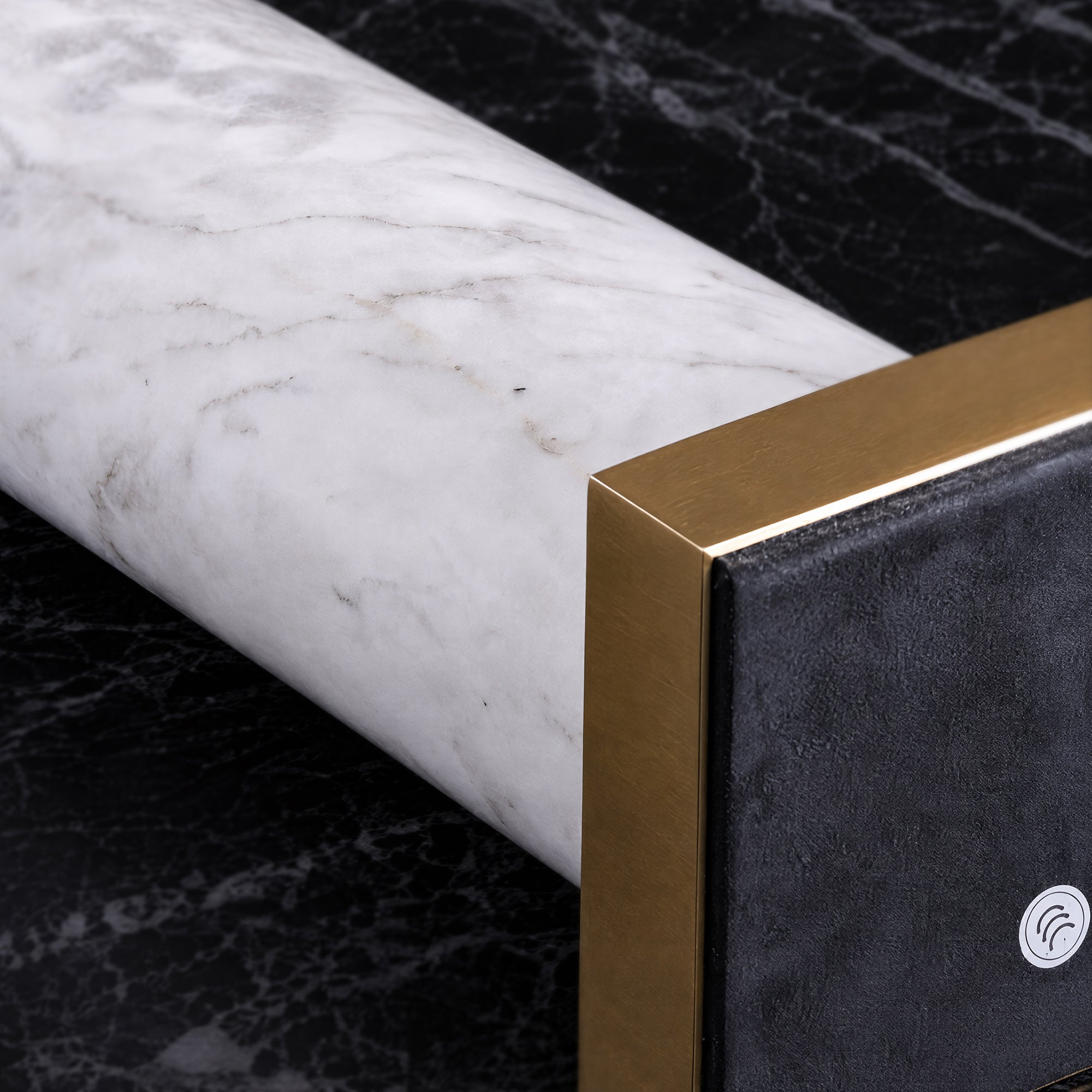 Close up detail of white natural marble body attached to brass square base with protective bottom pad